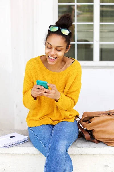 Joyeux jeune femme en utilisant un téléphone portable — Photo