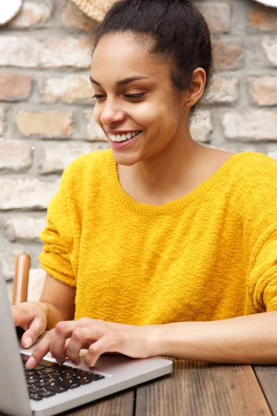 Sorridente giovane donna nera utilizzando il computer portatile al caffè — Foto Stock