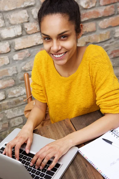 Sorridente giovane donna che lavora sul computer portatile — Foto Stock