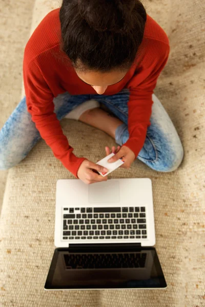 Mujer joven usando tarjeta de crédito con ordenador portátil — Foto de Stock