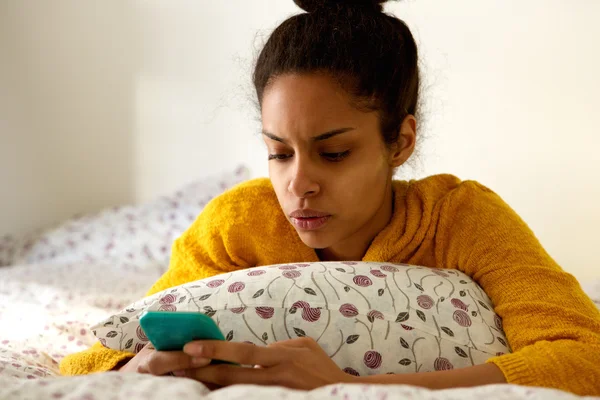 Besorgte junge Frau schaut aufs Handy — Stockfoto