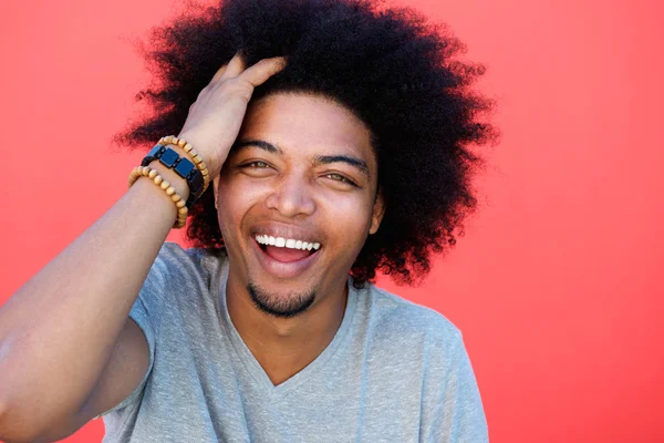 Lachender junger Mann mit der Hand im Afro-Haar — Stockfoto