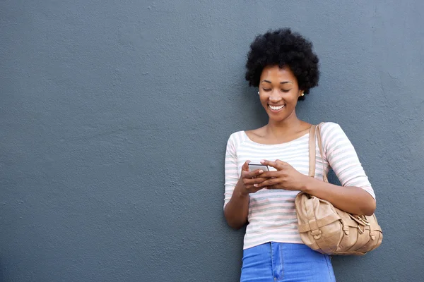 Mujer sonriente mirando el teléfono móvil — Foto de Stock