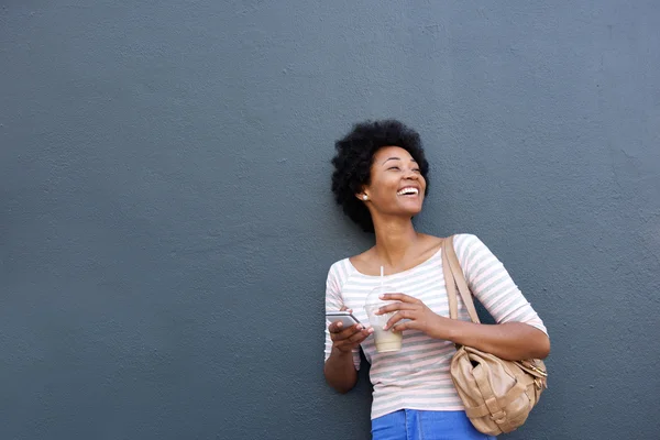 Lächelnde Afrikanerin mit Getränk und Handy — Stockfoto