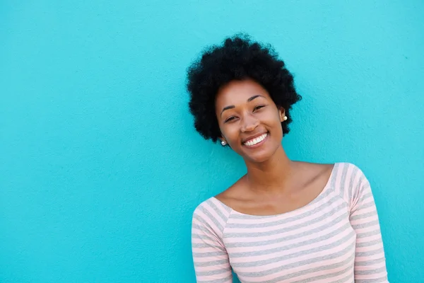 Cheerful woman standing against blue wall — Stock Photo, Image