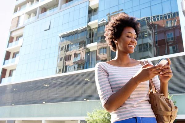 Jonge vrouw in de stad met mobiele telefoon — Stockfoto