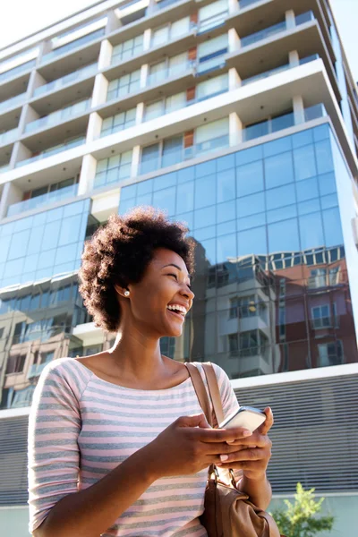 Young woman laughing with cell phone — Stock Photo, Image