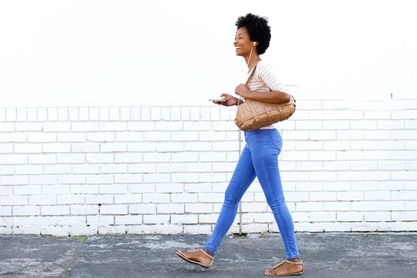 Kobieta, chodzenie na chodniku z inteligentny telefon — Zdjęcie stockowe