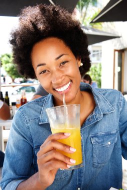 Gülümseyen kadın café'de portakal suyu içme 