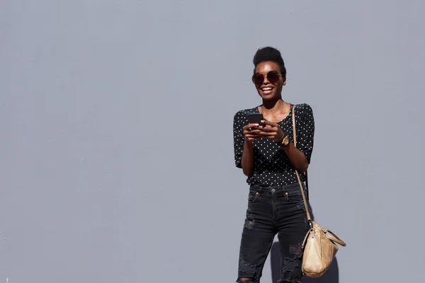 Mujer afroamericana con bolsa y teléfono móvil — Foto de Stock