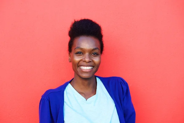 Uśmiechnięta młoda czarna dama na czerwonym tle — Zdjęcie stockowe