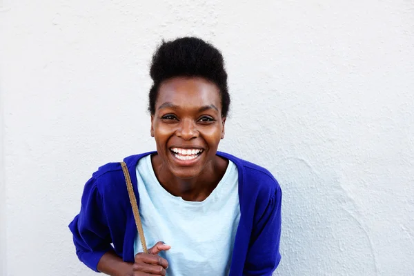 Jovem mulher africana sorrindo contra a parede branca — Fotografia de Stock