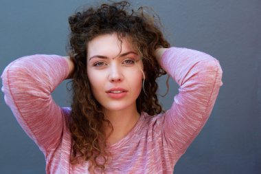 Eller başının arkasında duran genç kadın