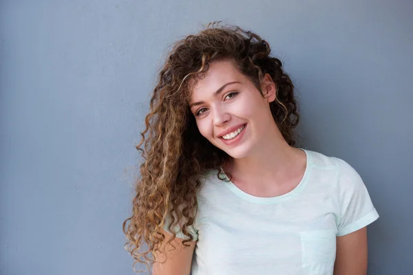 Glücklicher Teenager lächelt gegen graue Wand — Stockfoto