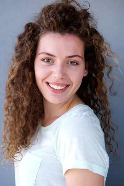 Sonriente joven adolescente chica contra la pared gris —  Fotos de Stock