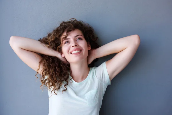 Sonriente adolescente chica de pie con las manos detrás de la cabeza — Foto de Stock