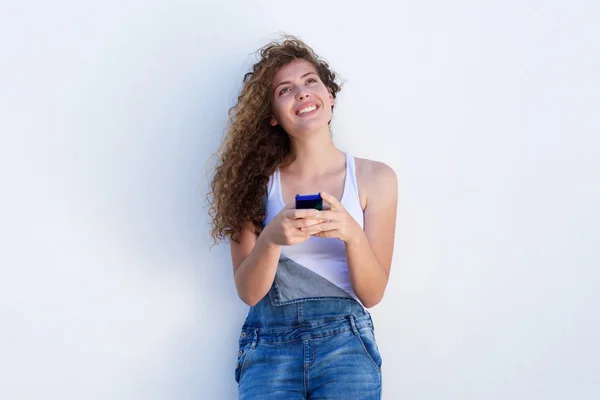 Glimlachend tiener opzoeken en slimme telefoon te houden — Stockfoto