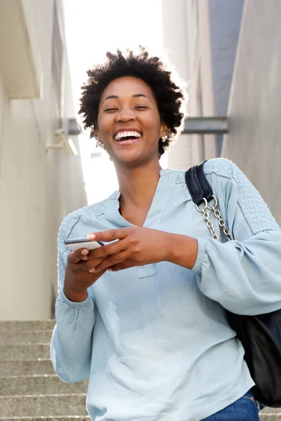 Nevetve fiatal afrikai hölgy mobiltelefon — Stock Fotó
