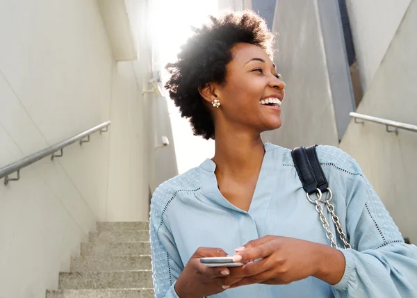 Smiling african lady with mobile phone — Stock Photo, Image