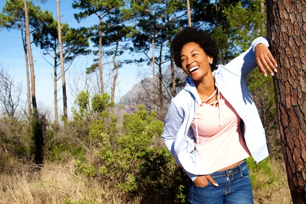 Mujer elegante apoyada en el tronco del árbol — Foto de Stock