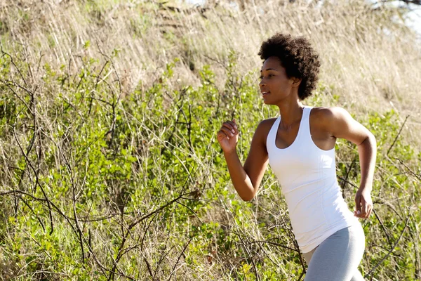Fit young african woman running outdoors — Stock Photo, Image