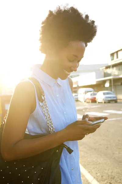 Gelukkig Afrikaanse vrouw met behulp van mobiele telefoon — Stockfoto