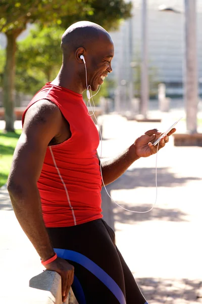 Африканский спортсмен в парке слушает музыку — стоковое фото