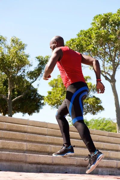 Young man jogging on stairs outdoors — Stock Photo, Image