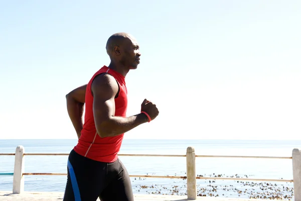 Homem africano correndo no passeio marítimo — Fotografia de Stock