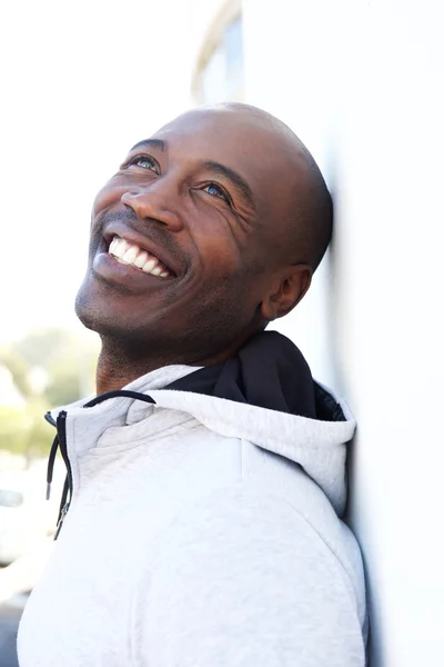 Sonriente hombre africano inclinado a la pared —  Fotos de Stock