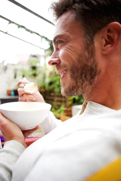 Cheerful older man eating healthy breakfast — Stock Photo, Image