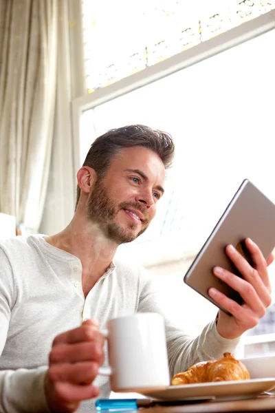 Sorrindo homem de meia idade com tablet e café — Fotografia de Stock