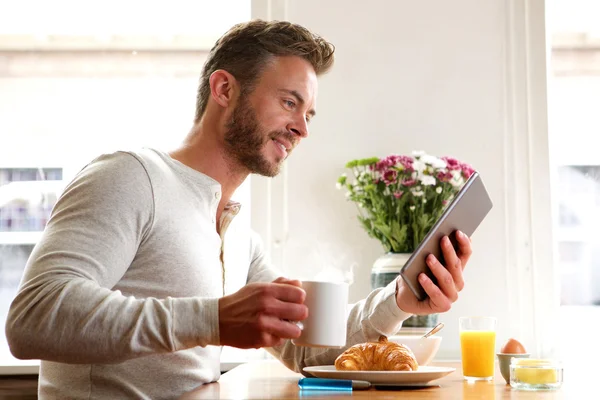 Красивый мужчина читает новости на планшете — стоковое фото