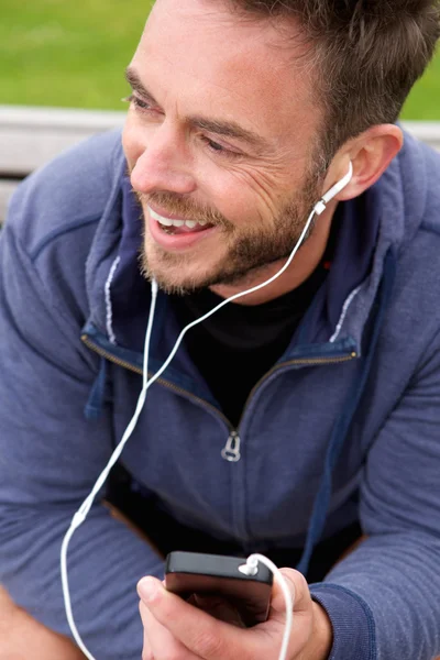 Joyeux jogger assis avec des écouteurs — Photo