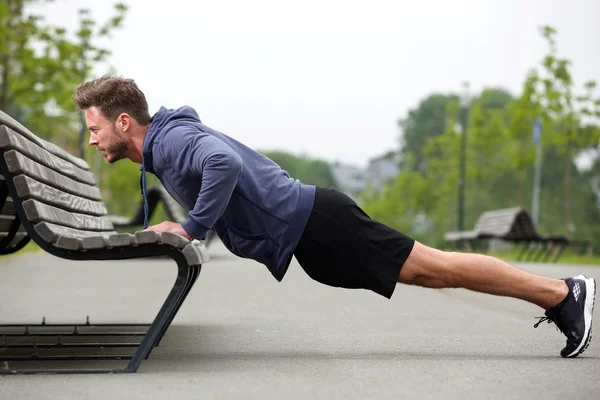 Attraktiver Mann macht Liegestütze draußen — Stockfoto