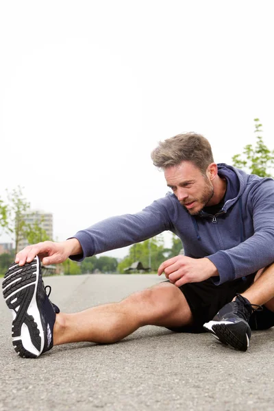 Determined runner in the middle of stretch for workout routine — Stock Photo, Image