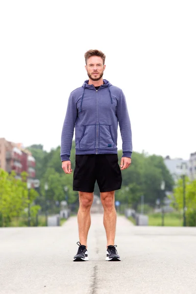 Attractive male athlete standing in middle of street — Stock Photo, Image