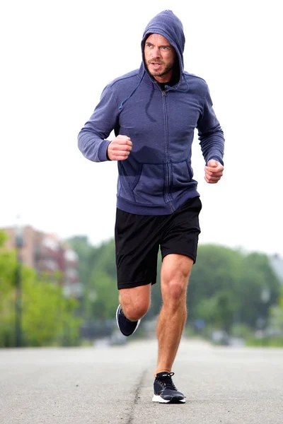 Confident middle age athlete running in street — Stock Photo, Image