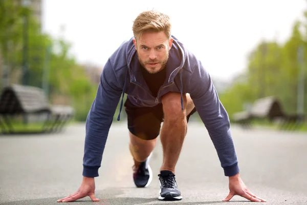Healthy runner in starting position outside — Stock Photo, Image