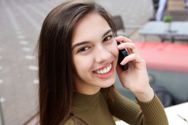 Gülümseyen genç kadın telefon görüşmesi dışında üzerinde