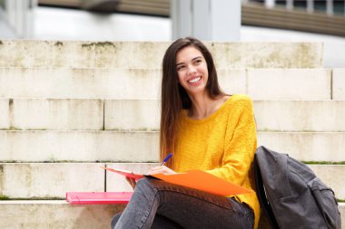 Merdivenleri oturan kendine güvenen öğrenci