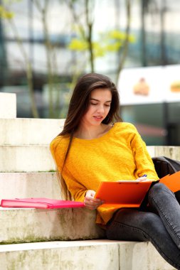 Basamaklarında oturan çekici öğrenci 