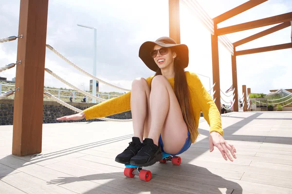 Lächelnde junge Frau auf Skateboard — Stockfoto