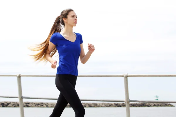 Vrouwelijke runner buiten door de zee — Stockfoto