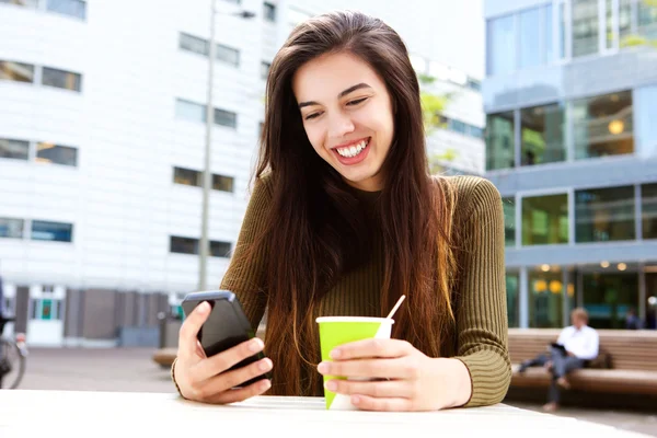 携帯電話を持つ若い女性の笑みを浮かべてください。 — ストック写真
