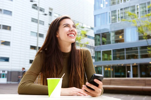 Sonriente mujer joven sosteniendo el teléfono celular —  Fotos de Stock