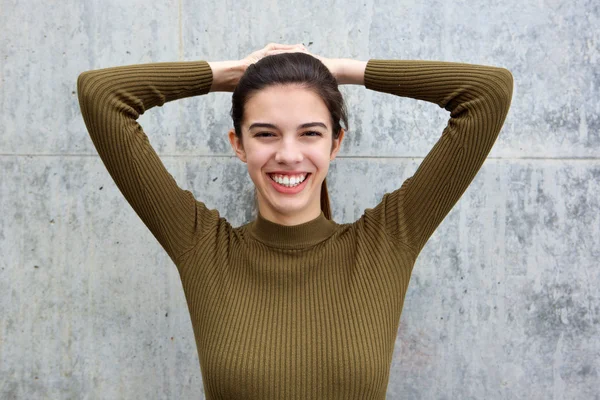 Sorridente giovane donna con entrambe le mani sulla testa — Foto Stock