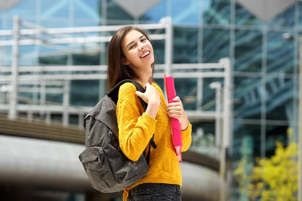 Studente sorridente che tiene zaino e notebook — Foto Stock