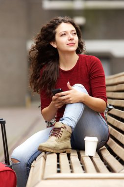 telefon ile bankta oturan kadın 