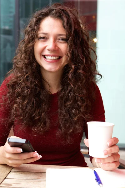 Lachende jonge vrouw die zit op café — Stockfoto